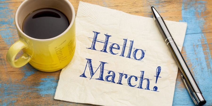 Welcome March written on a napkin with a cup of coffee and a pen on the table