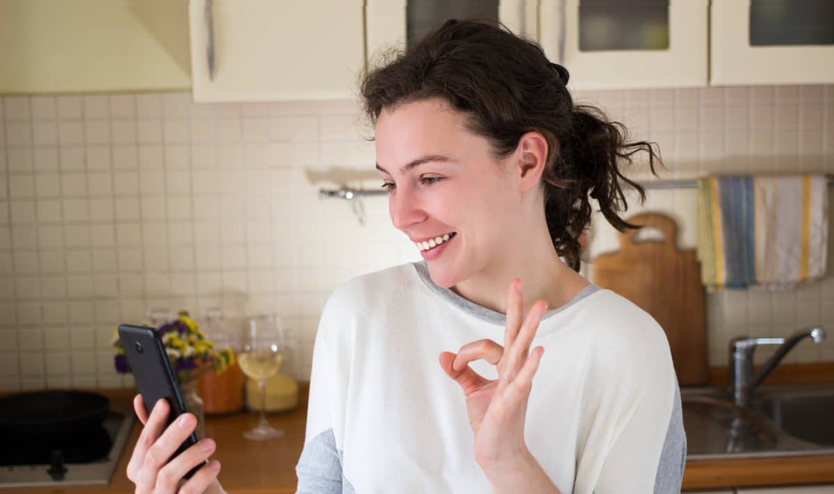 Woman with phone in her kitchen
