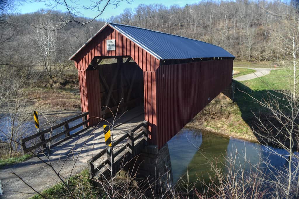A red covered bridge over a creek
