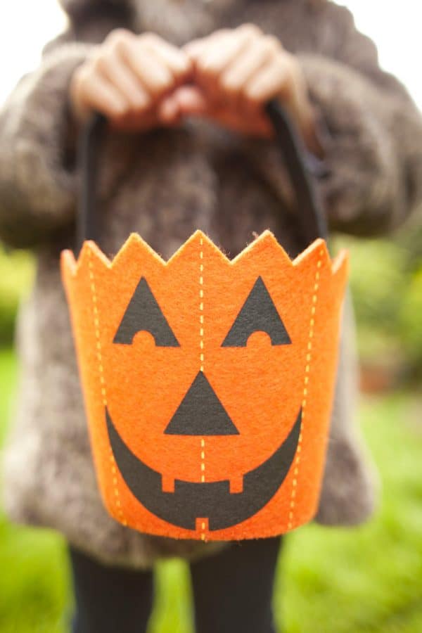 Child with pumpkin trick or treat bag
