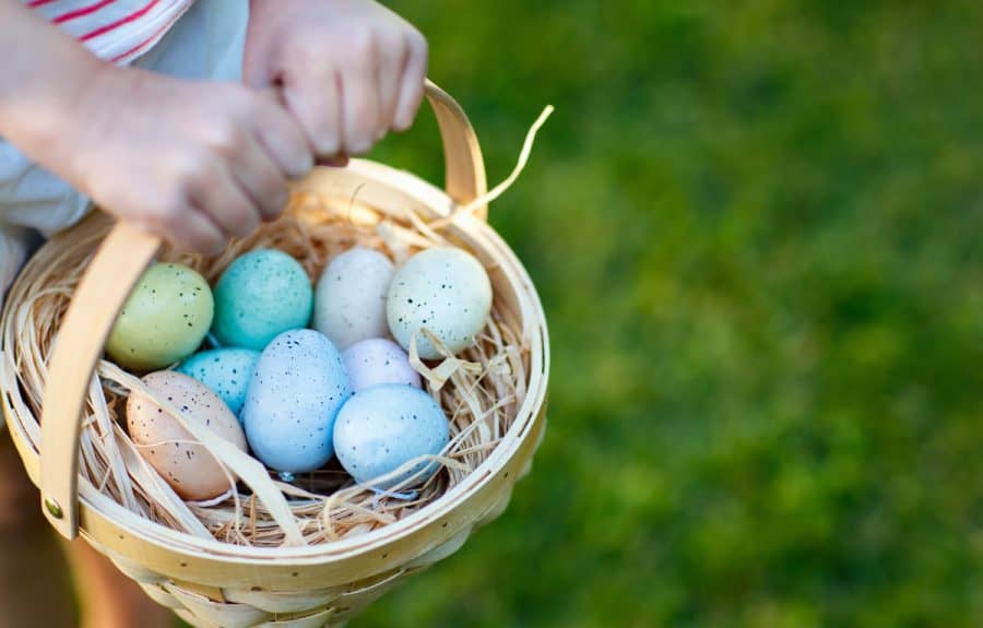 Girl carrying an Easter basket full of eggs

