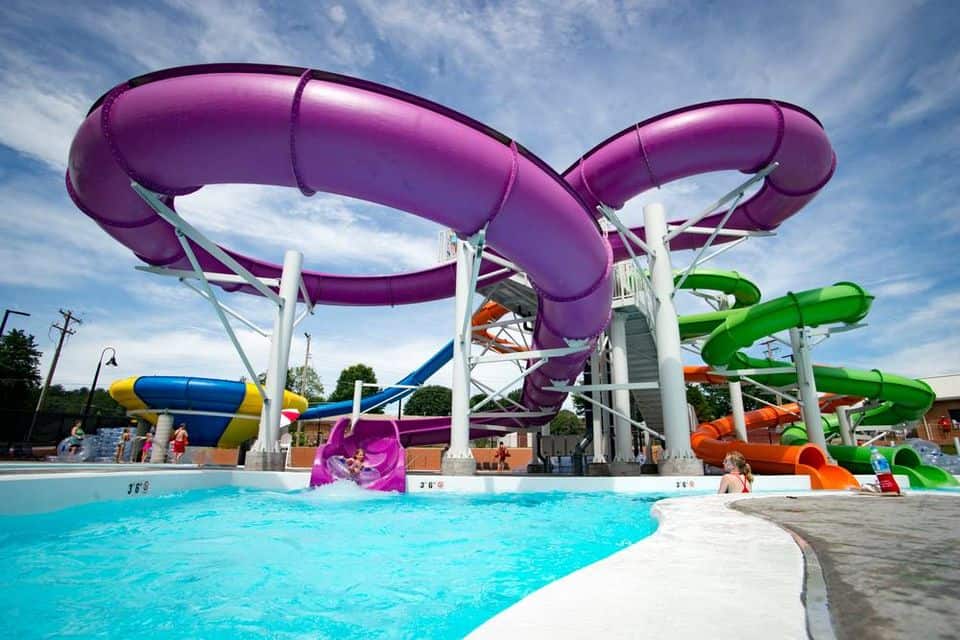 kids playing in the pool and on a water slide
