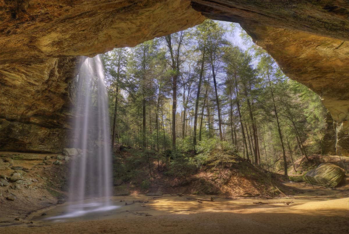 Looking out of Ash Cave at the forest and a waterfall