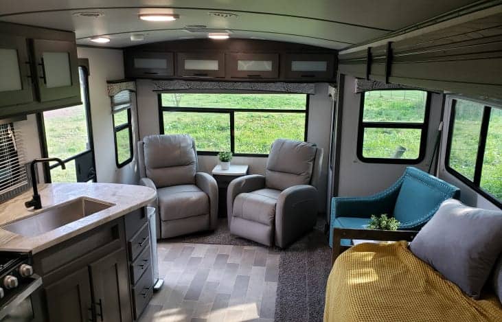 Inside of an RV with chairs and kitchen sink area