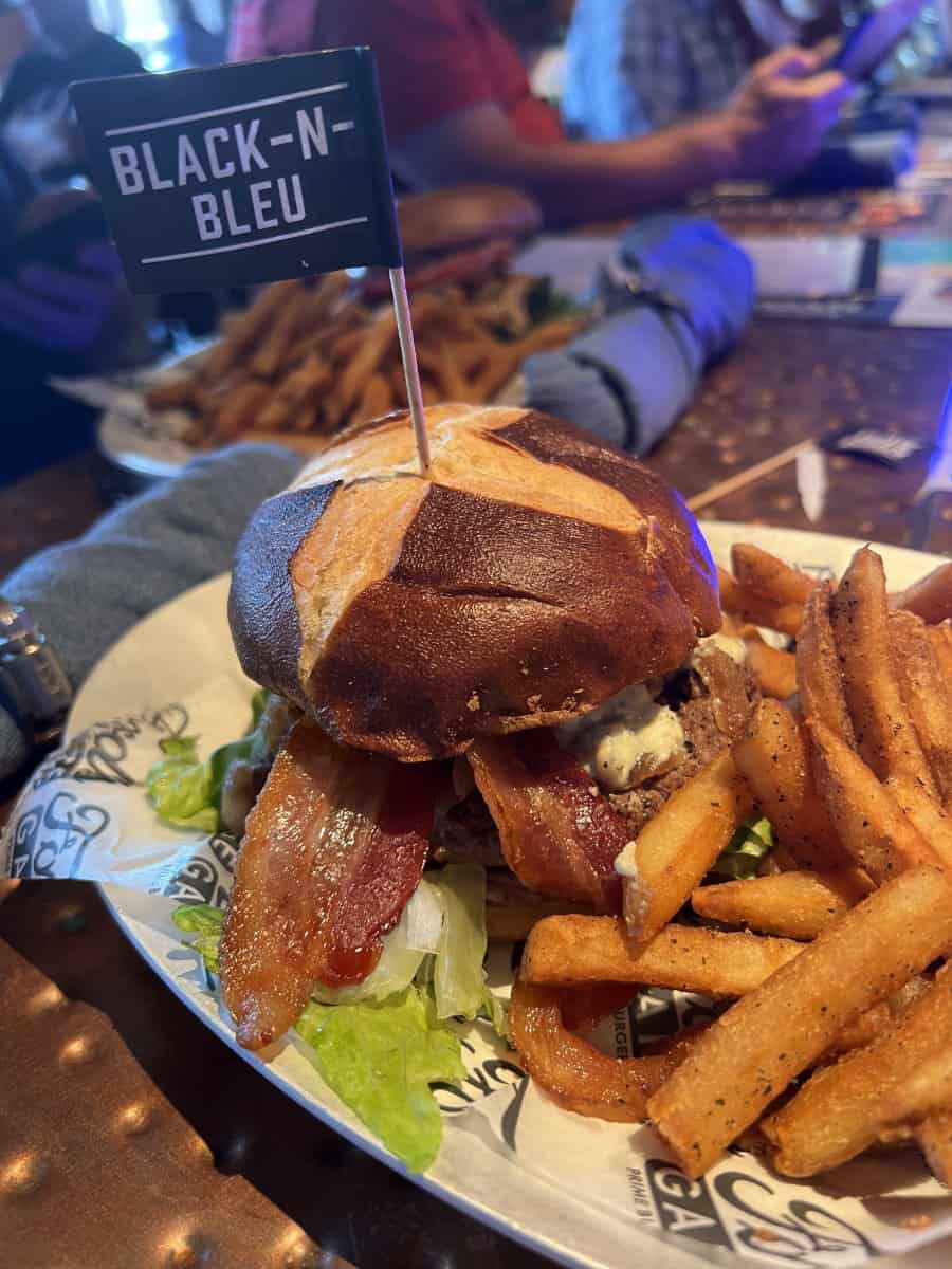 A Black and Bleu Burger with bacon and fries on the bar at Ford's Garage in Cincinnati