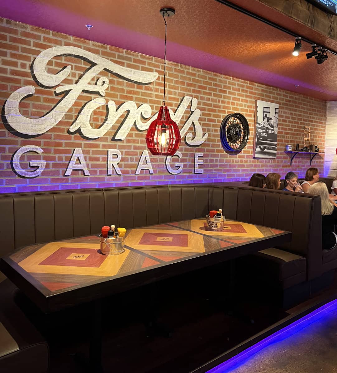 Large table seating with a brick wall and the Ford's Garage signage