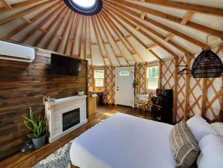The interior view of a yurt near Hocking Hills in Ohio; shows a bedroom with fireplace and bed