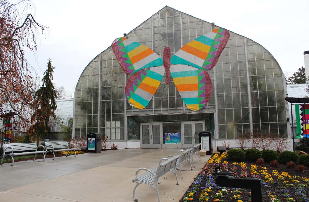the front of the Krohn Conservatory with walkway and benches