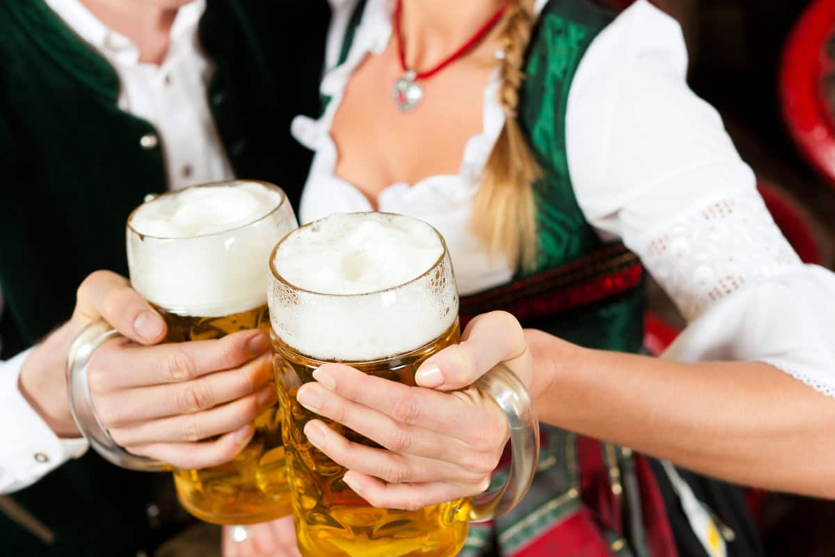woman and man dressed in German attire with beer steins