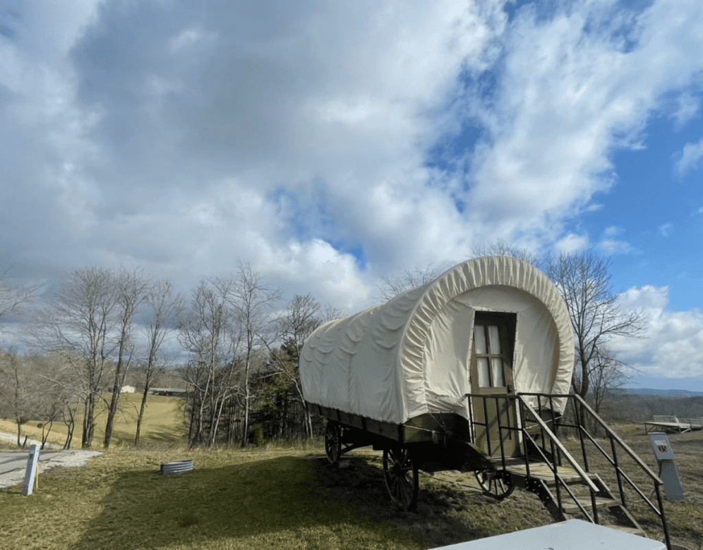 a covered wagon camper set in a campground setting